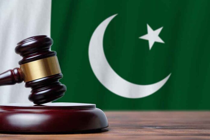 Gavel with Pakistan flag in the background.