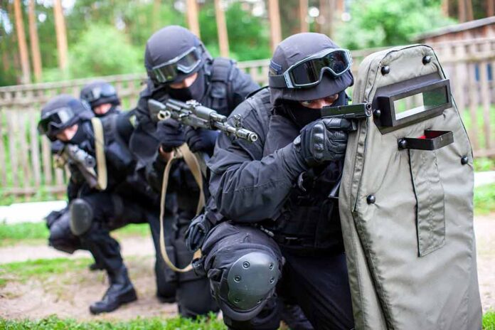 Tactical team with shields and rifles in formation.