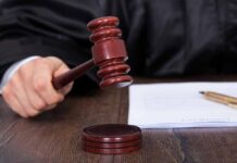 Judge striking a gavel on a wooden sound block.