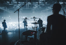 Band performing on stage with illuminated audience.