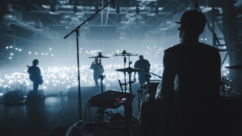 Band performing on stage with illuminated audience.