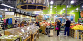 People shopping in a grocery store produce section.