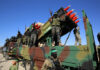 Armed soldiers on a truck with mounted missiles.