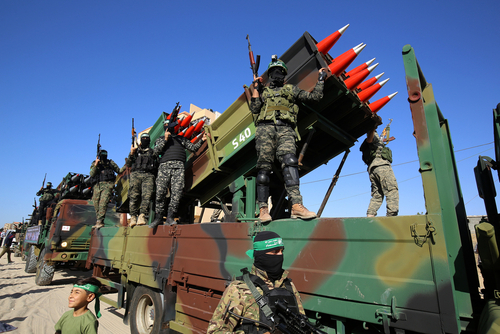 Armed soldiers on a truck with mounted missiles.