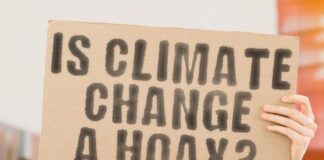 Person holding sign: "IS CLIMATE CHANGE A HOAX?"