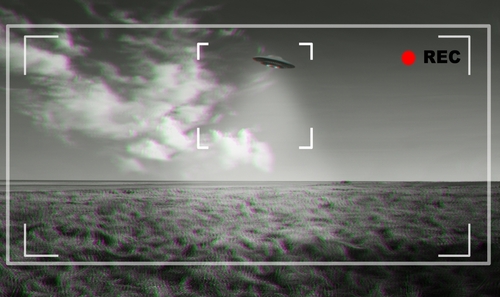 Black and white footage of UFO over a field.