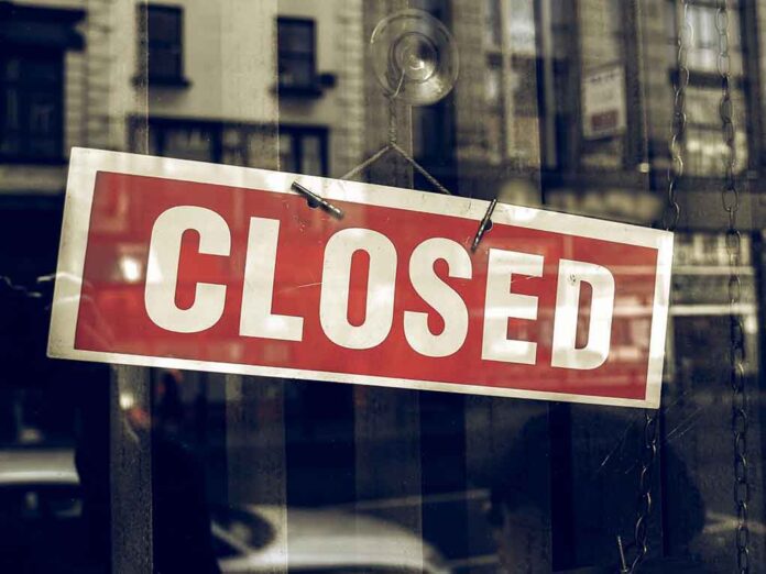 Red closed sign hanging in a window.