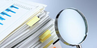 Stack of folders with a magnifying glass.