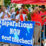 Protesters holding Reparations NOW banner at rally.