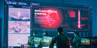 Military personnel monitor a command center screen showing missile launch alerts