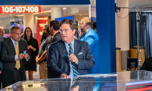 shutterstock2329709309-1jpg Man in suit speaking at a television studio.