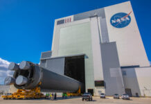 Blue Origin’s Engine BLAST: Hidden Risks Exposed A large rocket being transported outside a NASA building under a blue sky