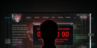 A person sitting in front of a computer screen displaying warning messages and code