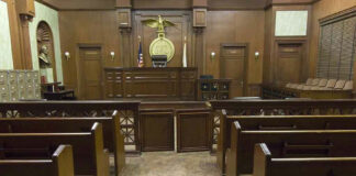 Empty courtroom with wooden benches and judges bench.