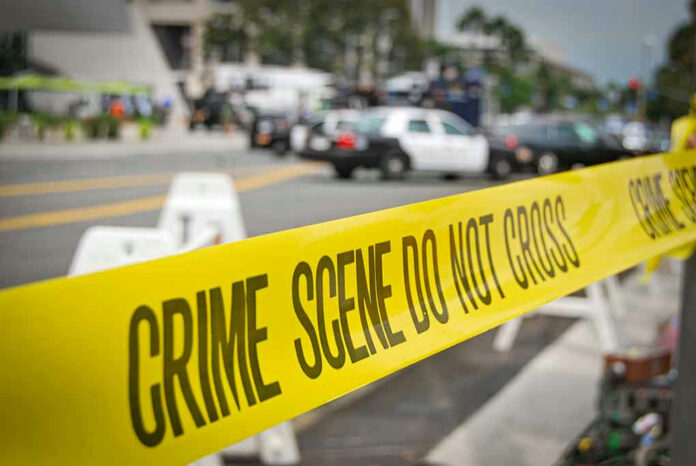 Yellow Crime Scene Do Not Cross tape across street.