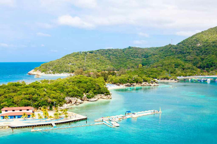 Tropical island with turquoise water and lush green hills.