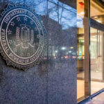 FBI seal on building wall near entrance doors.