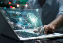 Person using laptop with futuristic data and analytics interface