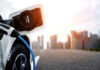 Electric car charging with city skyline background.