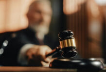 Judge's gavel striking sounding block in courtroom