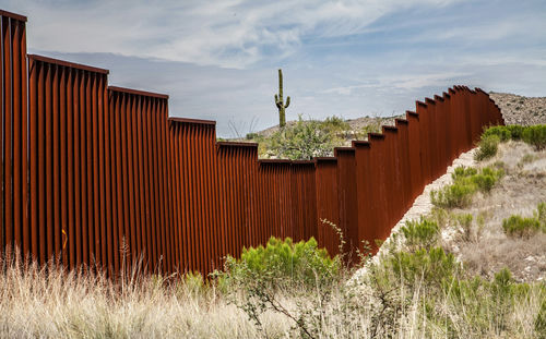 rust-colored border fence in a desert landscape