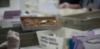 Workers handling mail-in ballots at a postal service.
