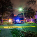 Small-Town Bloodbath Shocks Iowa Police car with flashing lights at a crime scene surrounded by caution tape