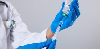 A healthcare professional preparing a syringe with a vaccine