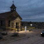 Police and forensic team at a crime scene near an abandoned church in the desert