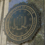 FBI: 7,000 Kids Found? FBI seal on a building exterior wall.