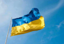 Ukraine’s Surprise PM Pick Sparks Accountability Fears Ukrainian flag waving against blue sky.