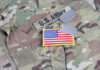 U.S. Army uniform with dog tags and flag patch.