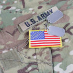 U.S. Army uniform with dog tags and flag patch.