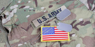 U.S. Army uniform with dog tags and flag patch.