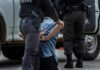 Child Support Rage Sparks Deadly Store Attack Police officer arresting and handcuffing a person.