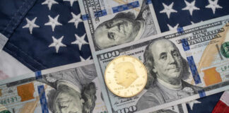 American flag background with hundred dollar bills and coin
