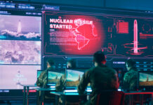 Military personnel monitor a command center screen showing missile launch alerts