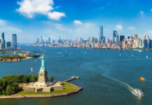 Millionaires Bolt—NYC Left Holding Bag Statue of Liberty with New York City skyline background.