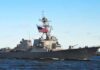 Navy’s “Crappy Ship” Exposes Deep Rot naval destroyer with flags sailing on open water