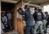 Law enforcement officers conducting a property recovery raid