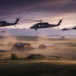 Military helicopters fly low over a rural farm at sunset